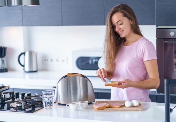young-happy-smiling-woman-preparing-toasts-breakfast-kitchen-home-early-morning_122732-2807
